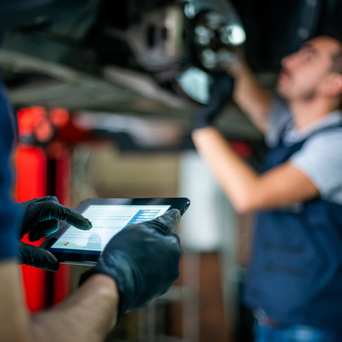 mechanic inspecting tires on a car