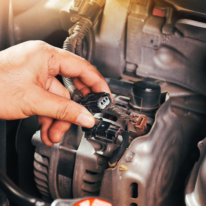 someone inspecting an alternator for a car