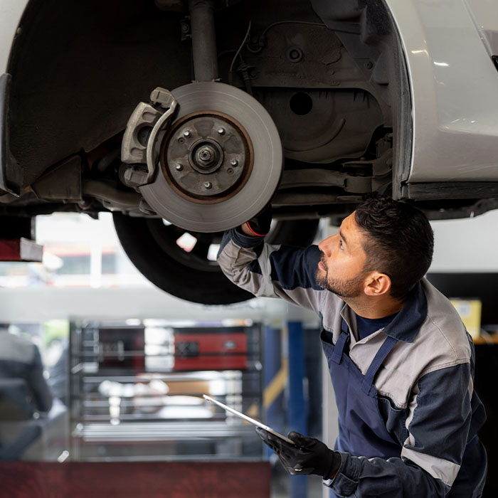 man inspecting brakes and rotors on a car
