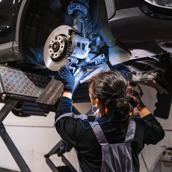 mechanic inspecting brakes and rotors on a car