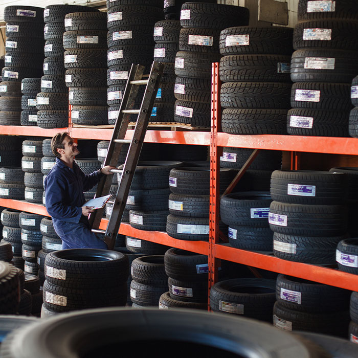 man inspecting tires on a rack