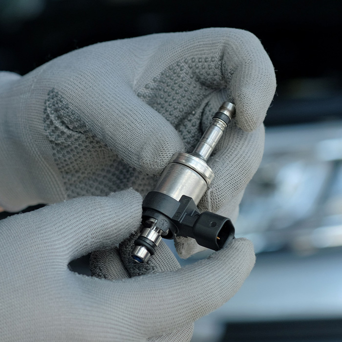 someone inspecting a fuel injector for a car